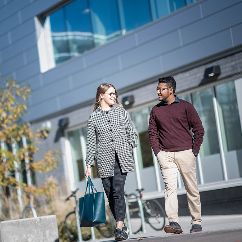 female and male students walking on campus