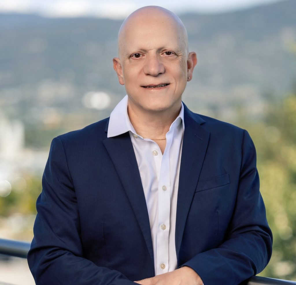 Faculty of Management Dean, Gady Jacoby, poses in front of the Okanagan Valley