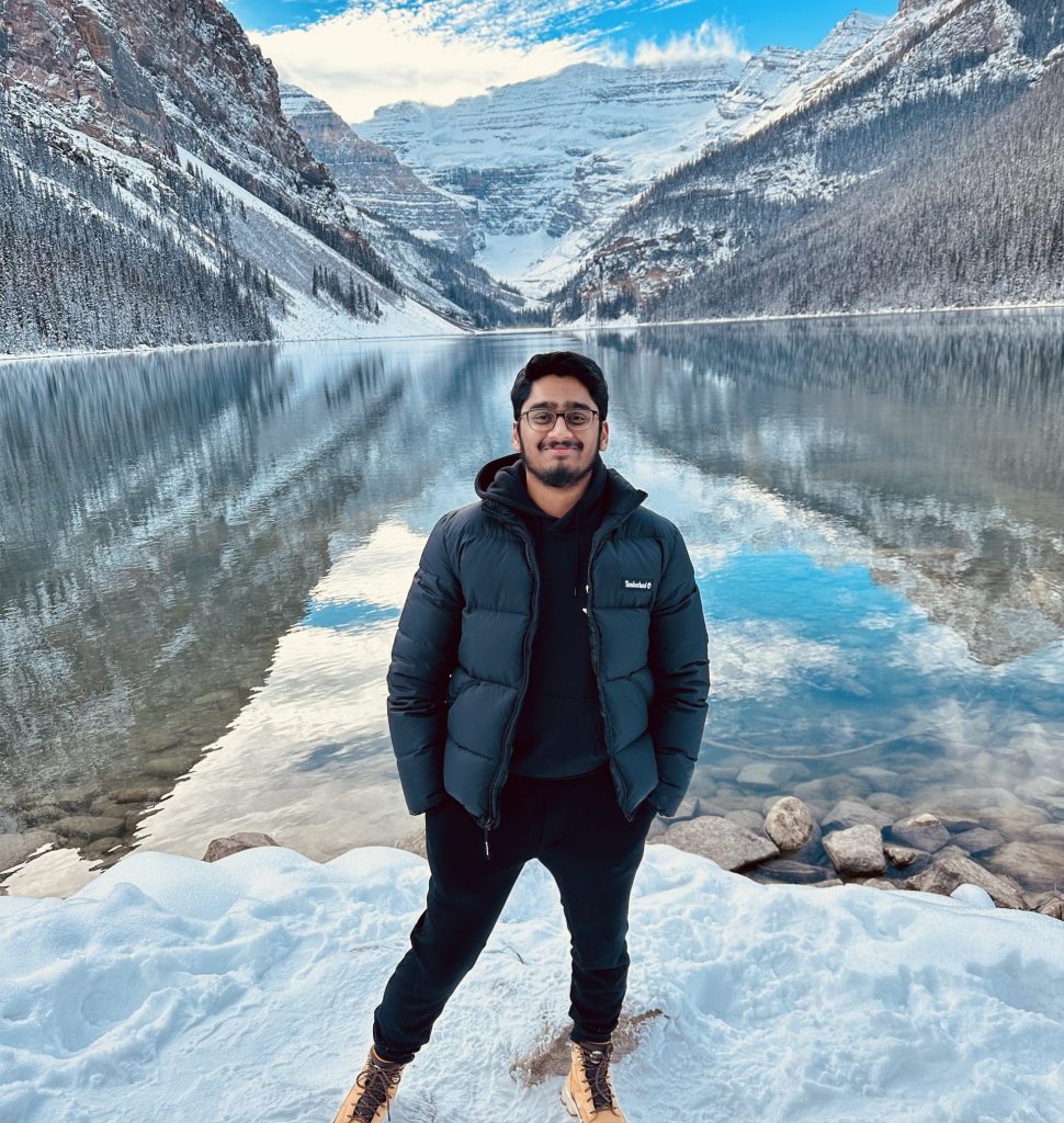 Kanish stands in front of lake and mountains